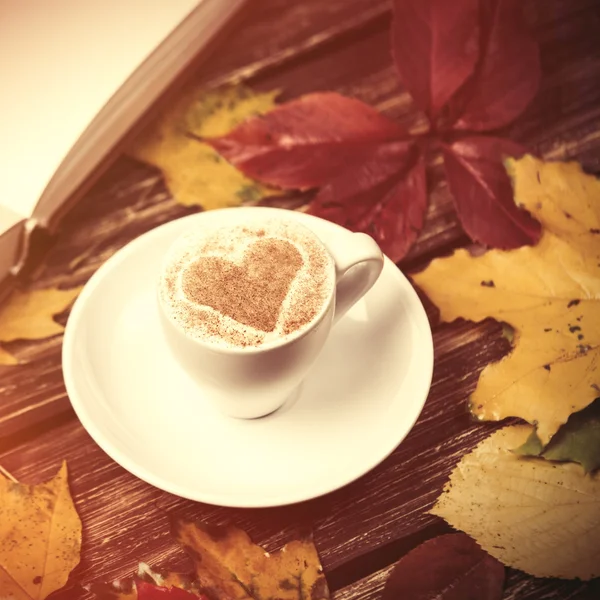 Herfst bladeren, boek en koffie cup op houten tafel. — Stockfoto