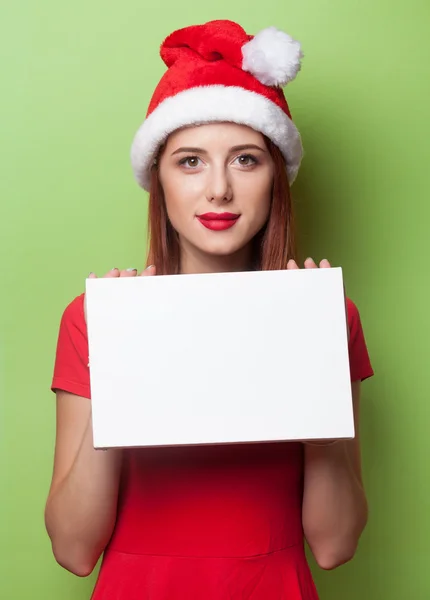 Vrouw in kerstmuts met bord — Stockfoto