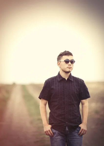 Mladý muž v sluneční brýle na venkově venkovní. — Stock fotografie