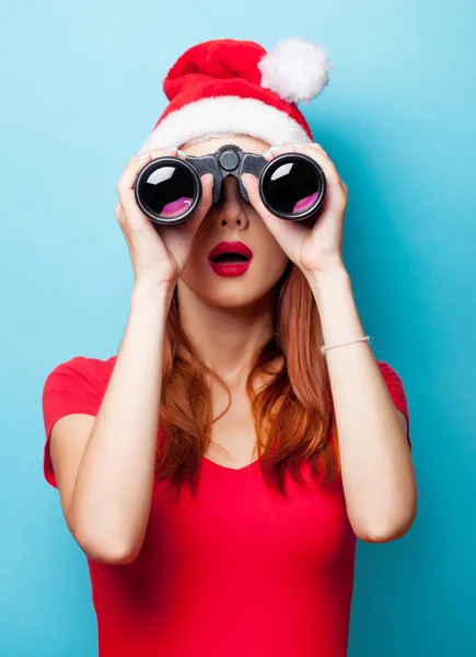 Woman in christmas hat with binocular — Stock Photo, Image
