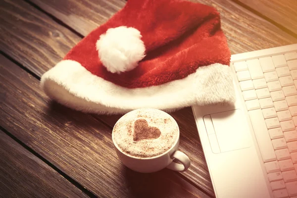 Beyaz dizüstü bilgisayar ve Noel babalar şapka 