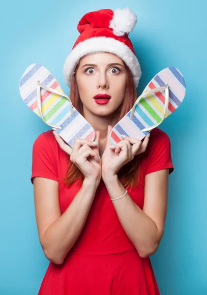 Vrouw in kerstmuts met slippers — Stockfoto