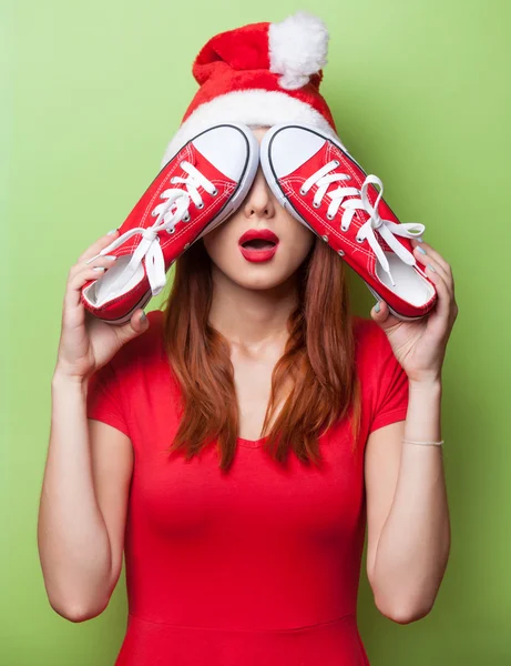 Mujer en sombrero de Navidad con zapatos de goma rojos —  Fotos de Stock