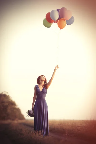 Flicka i blå klänning med ballonger — Stockfoto