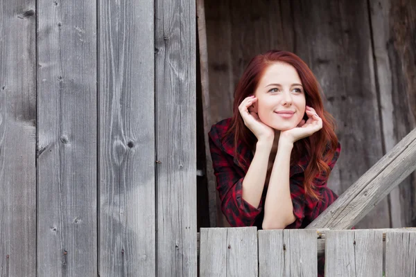 Vrouw in de buurt van een houten muur. — Stockfoto