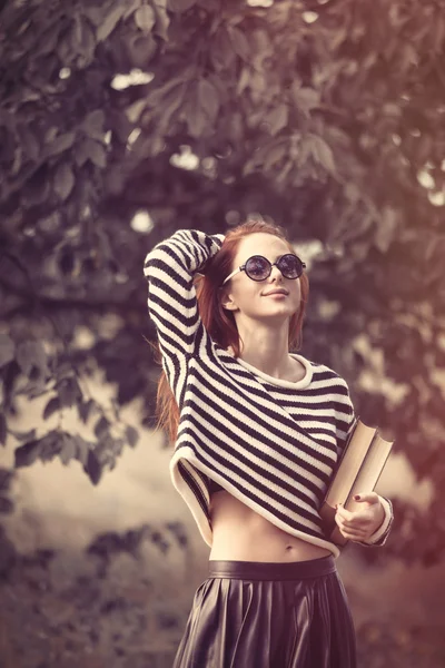 Девушка в полосатом свитере с книгами — стоковое фото