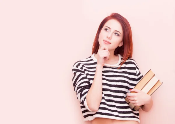 Frau mit Büchern auf rosa Hintergrund — Stockfoto