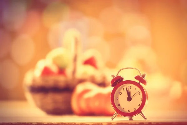 Little alarm clock and pumpkin — Stock Photo, Image