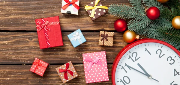 Gifts and clock with christmas baubles — Stock Photo, Image
