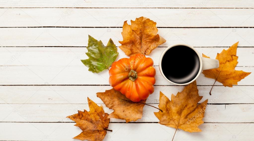 Cup and pumpkin with leaves