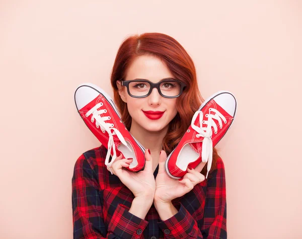 Tjejen i glasögon med röda joggingskor — Stockfoto