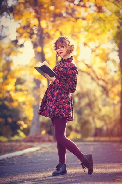 Рыжая девушка в очках с книгой — стоковое фото