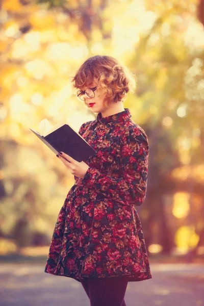 Roodharige meisje in glazen met boek — Stockfoto