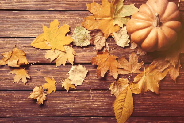 Pumpkin and  leaves on wooden — Stock Photo, Image