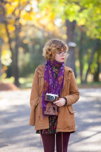 Chica con cámara en el parque de otoño — Foto de Stock