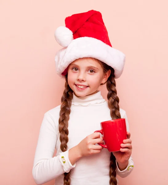 Menina com copo em chapéu de Papai Noel — Fotografia de Stock