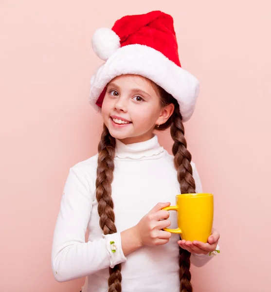 Girl with cup in Santa Claus hat — Stock Photo, Image