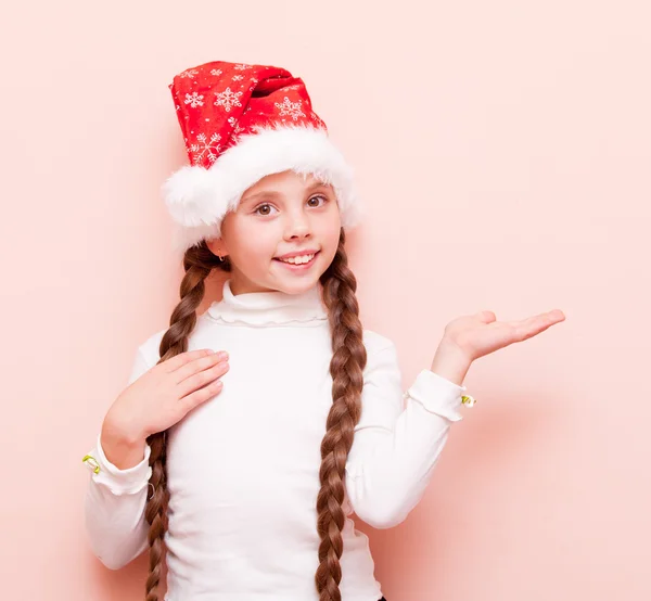 Dívka s copánky v Santa Claus klobouk — Stock fotografie