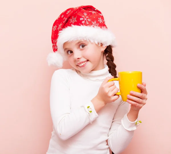 Menina com copo em chapéu de Papai Noel — Fotografia de Stock