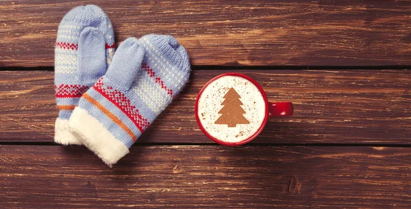 Wanten en cappuccino met kerstboom — Stockfoto