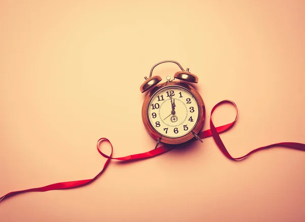 Alarm clock and red romantic ribbon — Stock Photo, Image