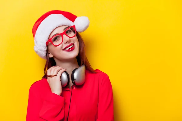 Mujer en Santa Claus sombrero con auriculares — Foto de Stock