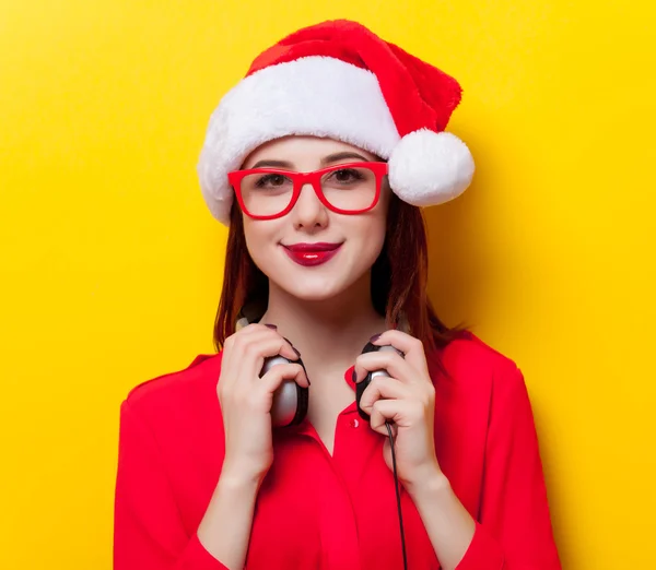 Mujer en Santa Claus sombrero con auriculares — Foto de Stock