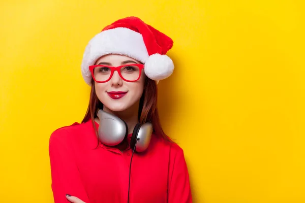 Mujer en Santa Claus sombrero con auriculares — Foto de Stock