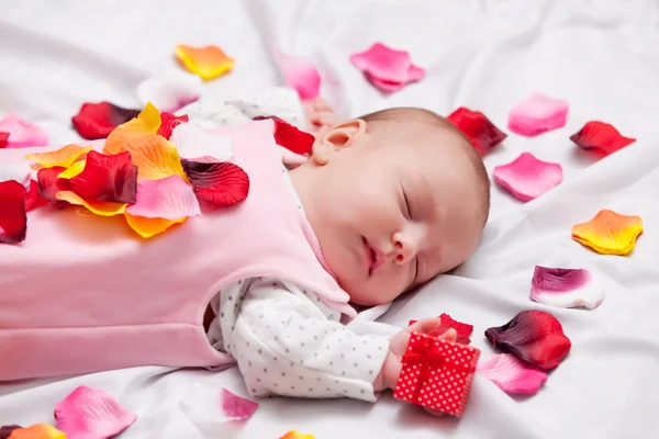 Kleine baby met rozenblaadjes — Stockfoto