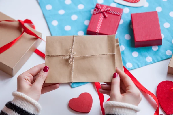 Femme préparant enveloppe et cadeau — Photo