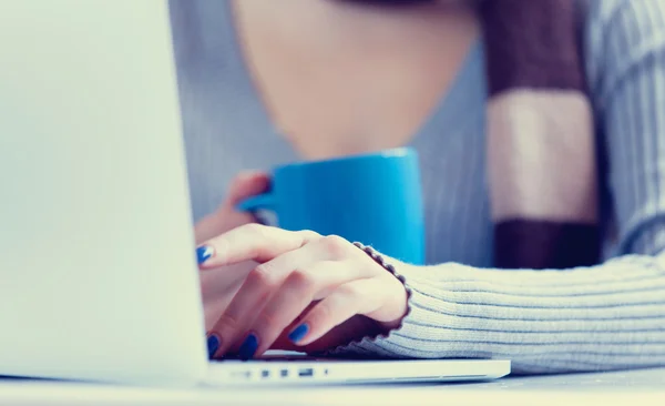 Cup near a woman with notebook computer — Stock Photo, Image