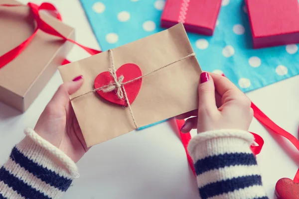 Woman preparing envelope and gift — Stock Photo, Image