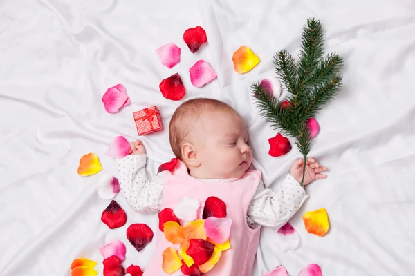 Małe dziecko z płatków róży — Zdjęcie stockowe