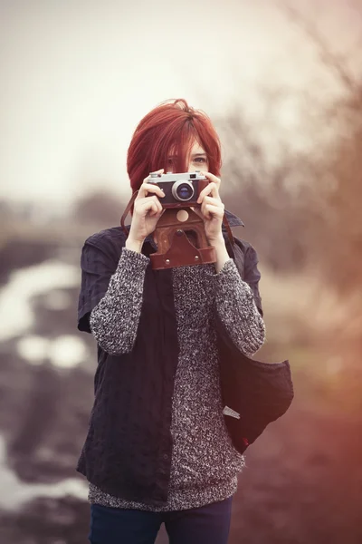 Mladá žena s vinobraní fotoaparát — Stock fotografie