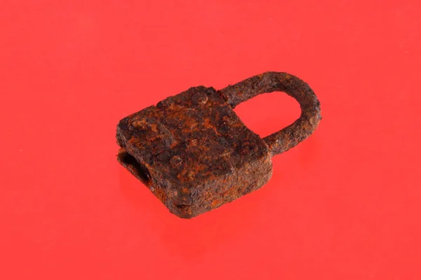 Rusty padlock on a red background. — Stock Photo, Image