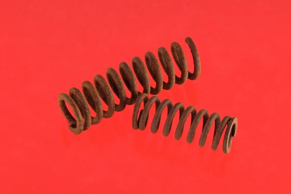 Steel spring on a red background — Stock Photo, Image