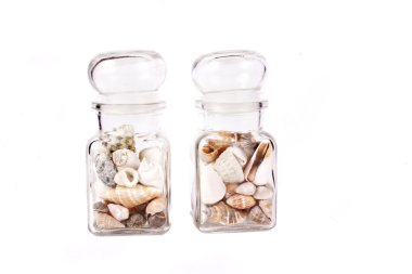 Beyaz arka plan üzerinde kavanoza küçük kabuklar