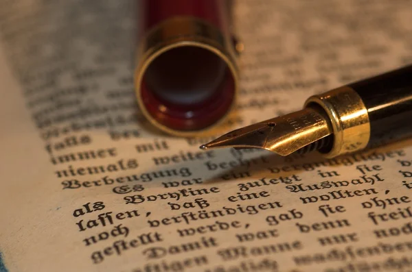 Золотая Ручка Старой Книге — стоковое фото