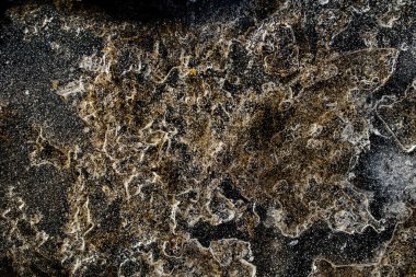 Donmuş bir su birikintisinde buzla yakın planda güzel ve soyut bir arkaplan.