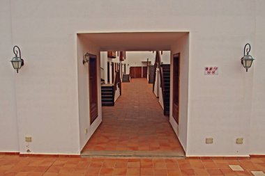 Beyaz duvarlı, ahşap basamaklı İspanyol evi olan ilginç bir avlu.