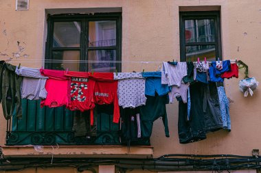 colorful laundry clothes drying outside a window in a Spanish city