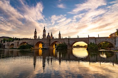 İspanya 'nın Zaragoza şehrinde bir yaz günü, nehre ve katedrale bakan güzel bir gün batımı.