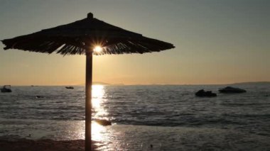 gün batımı sırasında plaj şemsiyesi