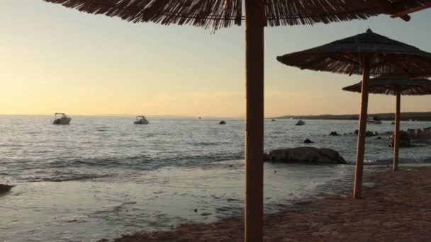 Sombrilla de playa durante la puesta del sol — Vídeos de Stock