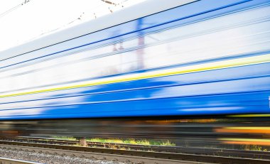 Yüksek hızda bulanık mavi yolcu vagonlu tren