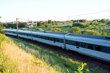 Bulanık fotoğraf ve arka planda yüksek hızda geçen yolcu araçları var.