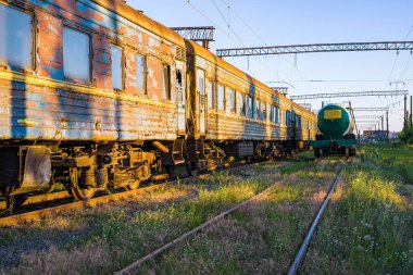 Eski, paslı ve terk edilmiş mavi yolcu vagonları demiryolunun yedek hattında.