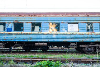 Eski, paslı ve terk edilmiş mavi yolcu vagonları demiryolunun yedek hattında.