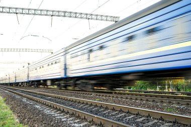 Yüksek hızda bulanık mavi yolcu vagonlu tren