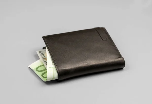 グレーの背景にドルとユーロ紙幣とレザーブラック財布 — ストック写真